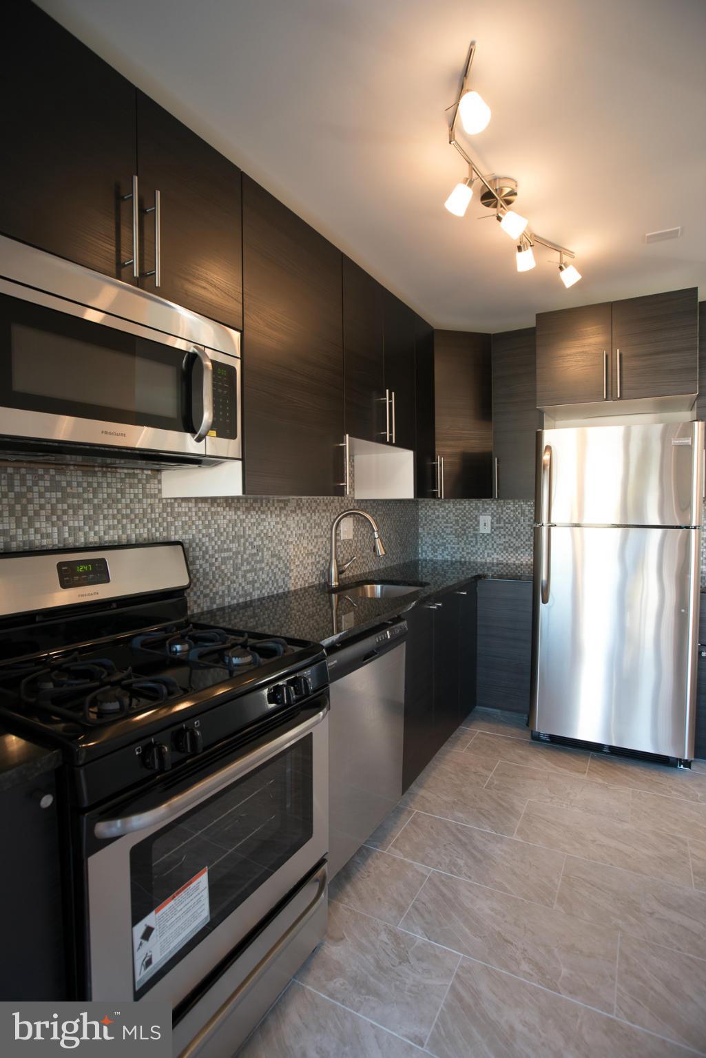 450 Torner Road Baltimore, MD 21221 - Photo 2 of 10 a kitchen with granite countertop a refrigerator and a stove