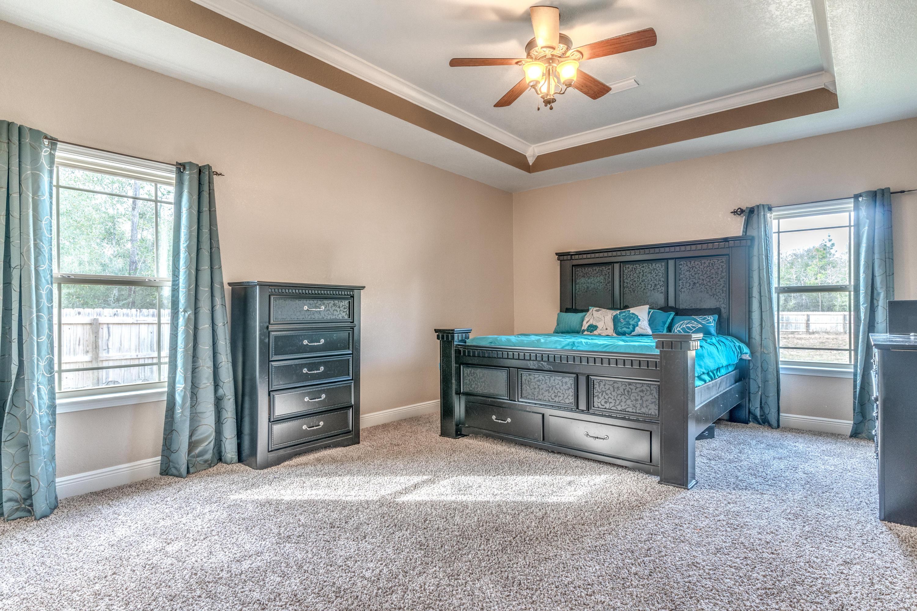 4005 Happy Trails Road Crestview, FL 32539 - Photo 12 of 24 a bedroom with a bed and a chandelier