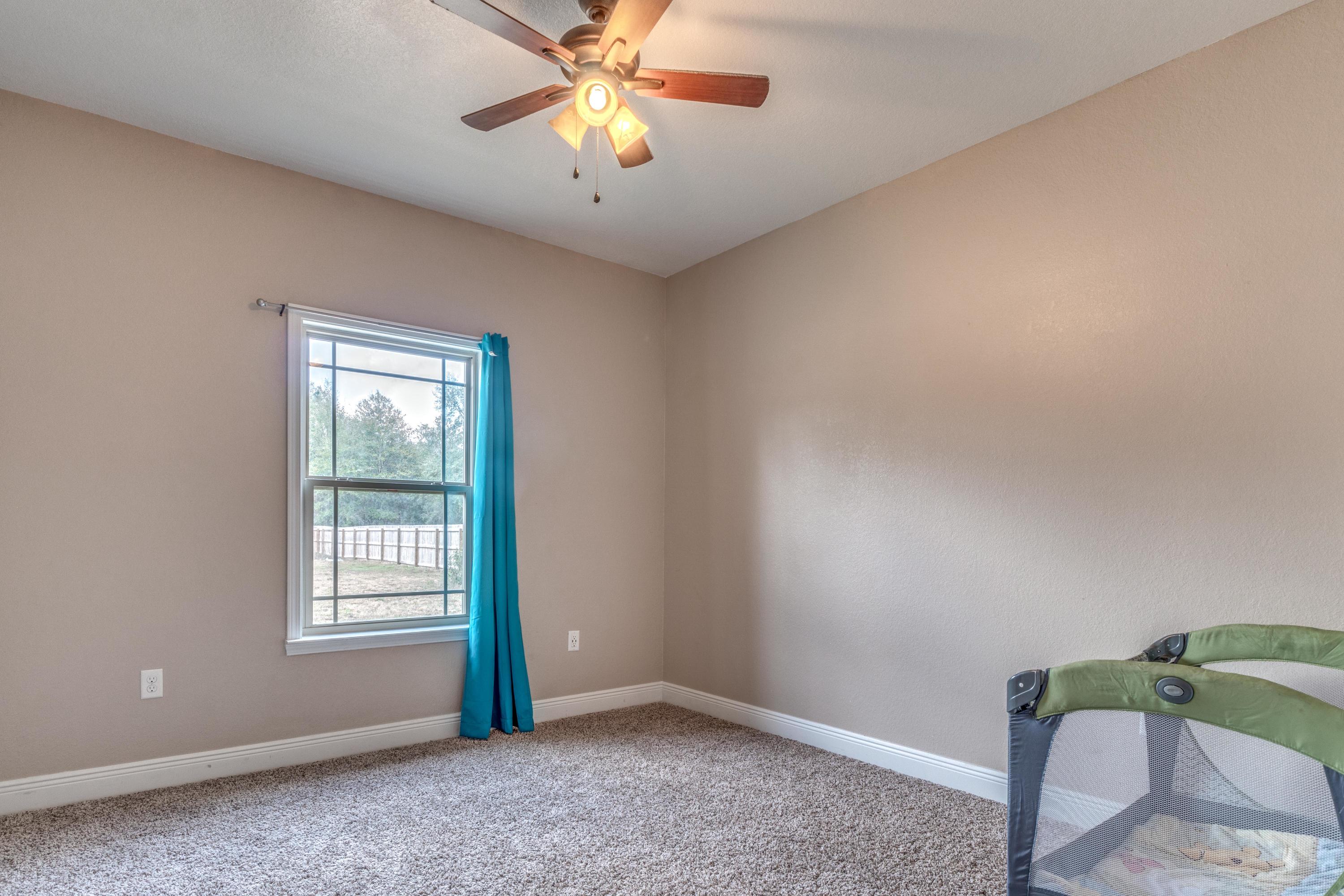 4005 Happy Trails Road Crestview, FL 32539 - Photo 16 of 24 an empty room with windows and fan