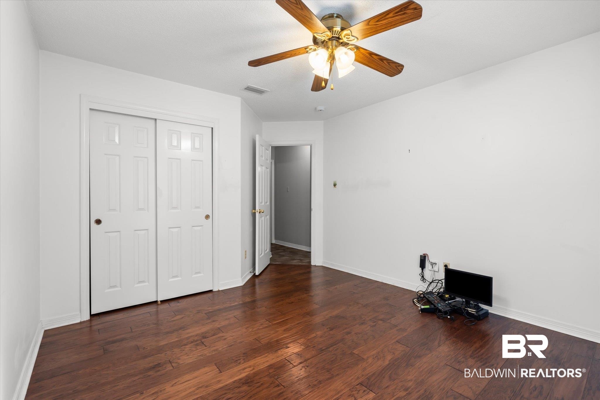 7410 East Lakeview Drive Mobile, AL 36695 - Photo 11 of 20 Unfurnished bedroom featuring dark hardwood / wood-style flooring, a closet, and ceiling fan