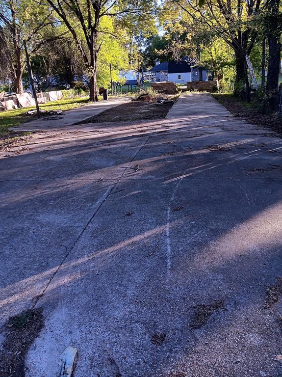 210 Spring Valley Street Gun Barrel City, TX 75156 - Photo 4 of 7 Paved driveway extending towards a residential structure, flanked by mature trees