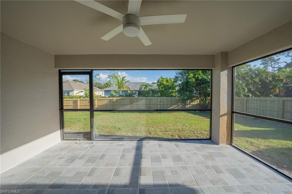 8152 Pelican Road Fort Myers, FL 33967 - Photo 23 of 24 Screened lanai featuring large format rectangular floor tiles, a ceiling fan, and expansive views of the fenced backyard
