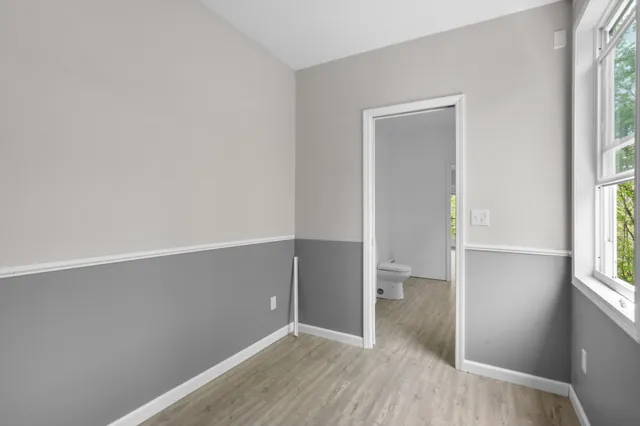 a view of a hallway with wooden floor and windows