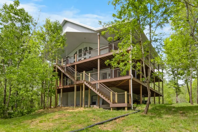 a front view of a house with a yard and green space