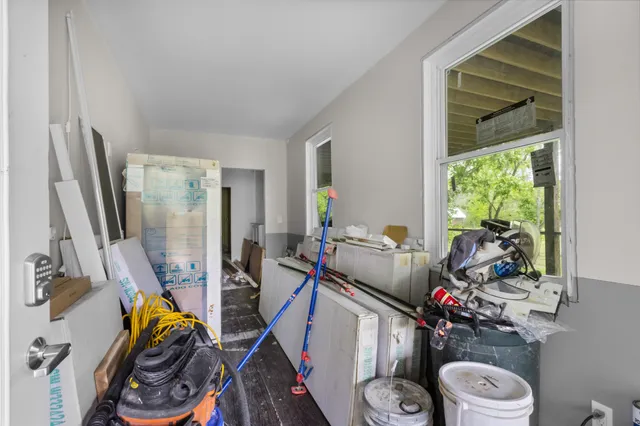 a kitchen with stainless steel appliances a stove a refrigerator and a dining table with wooden floors