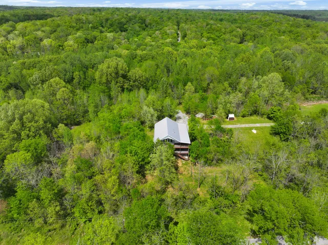 an aerial view of a house with yard and outdoor seating