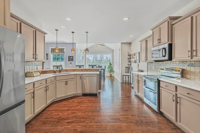 a large kitchen with stainless steel appliances sink a microwave and cabinets