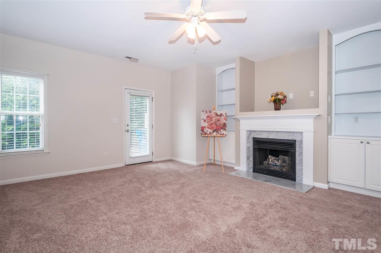 2301 Bay Harbor Drive Raleigh, NC 27604 - Photo 2 of 25 a living room with a fireplace and a chandelier