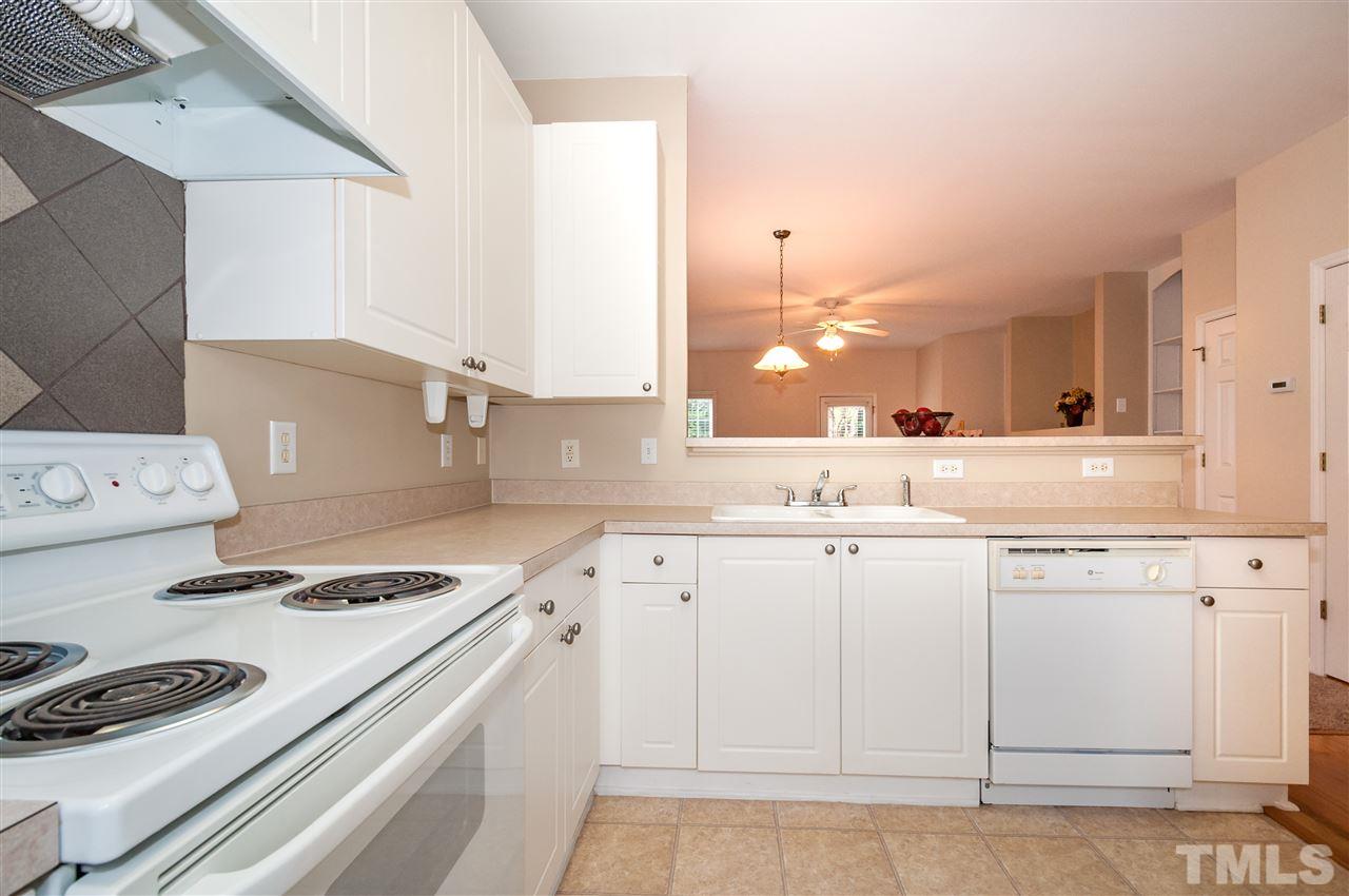2301 Bay Harbor Drive Raleigh, NC 27604 - Photo 6 of 25 a kitchen with granite countertop a white stove top oven and cabinets
