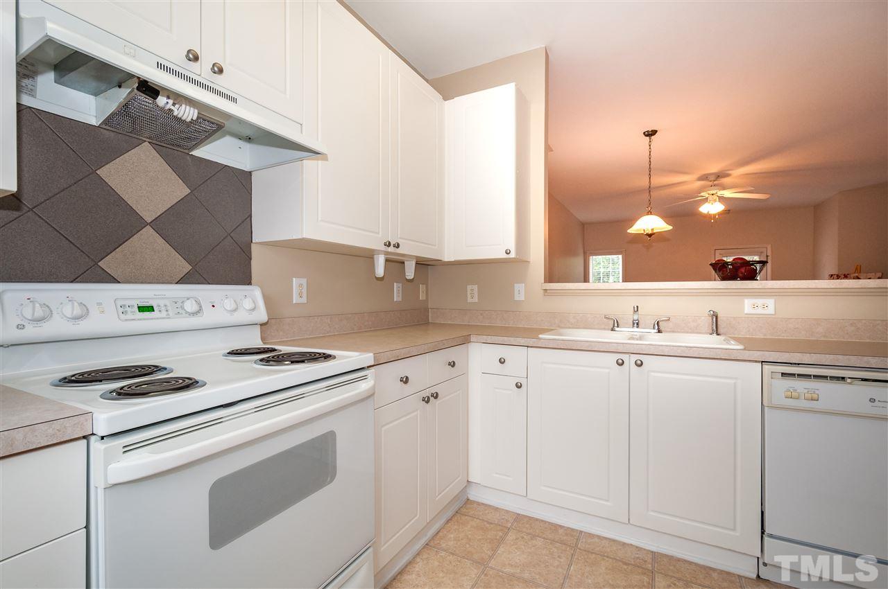 2301 Bay Harbor Drive Raleigh, NC 27604 - Photo 7 of 25 a kitchen with white cabinets and white appliances