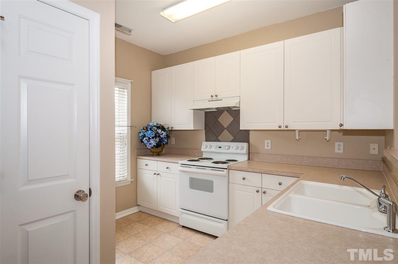 2301 Bay Harbor Drive Raleigh, NC 27604 - Photo 9 of 25 a kitchen with a stove and white cabinets