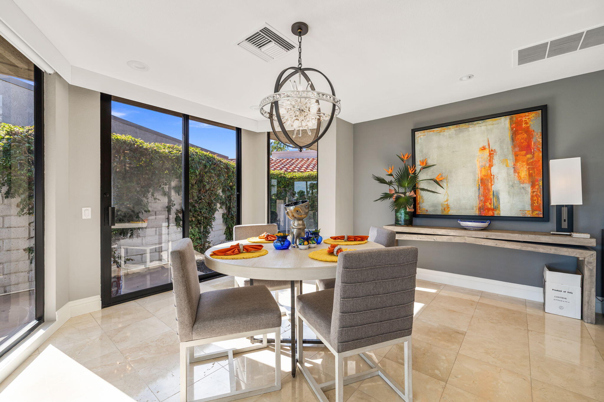 6 Barnard Court Rancho Mirage, CA 92270 - Photo 17 of 58 a dining room with furniture large windows and a chandelier
