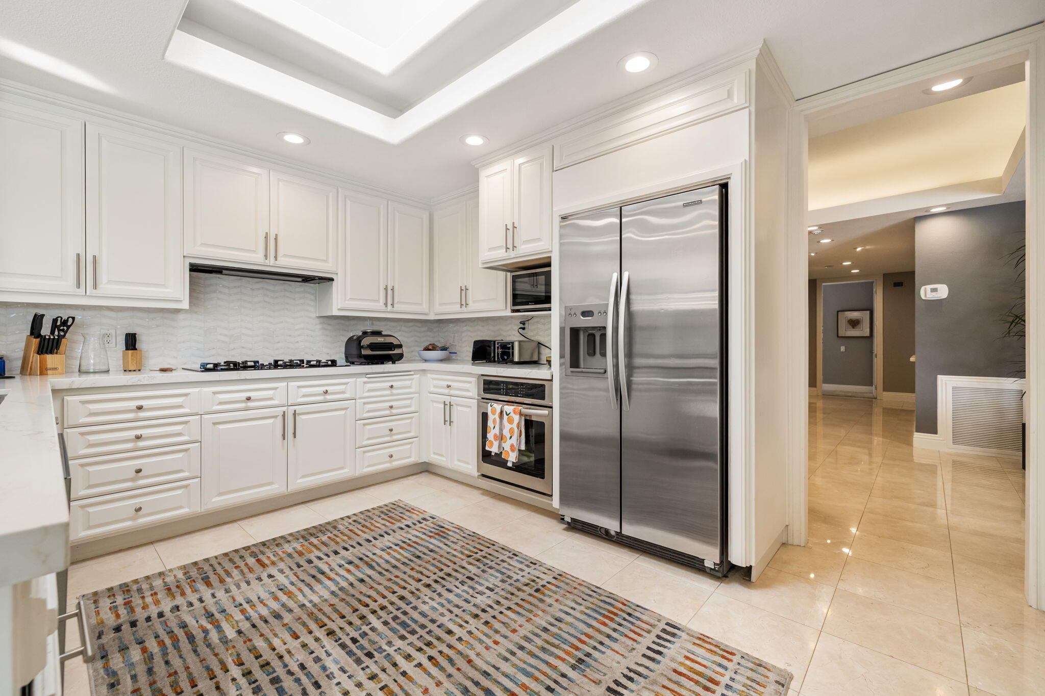 6 Barnard Court Rancho Mirage, CA 92270 - Photo 21 of 58 a kitchen with a refrigerator a sink and cabinets