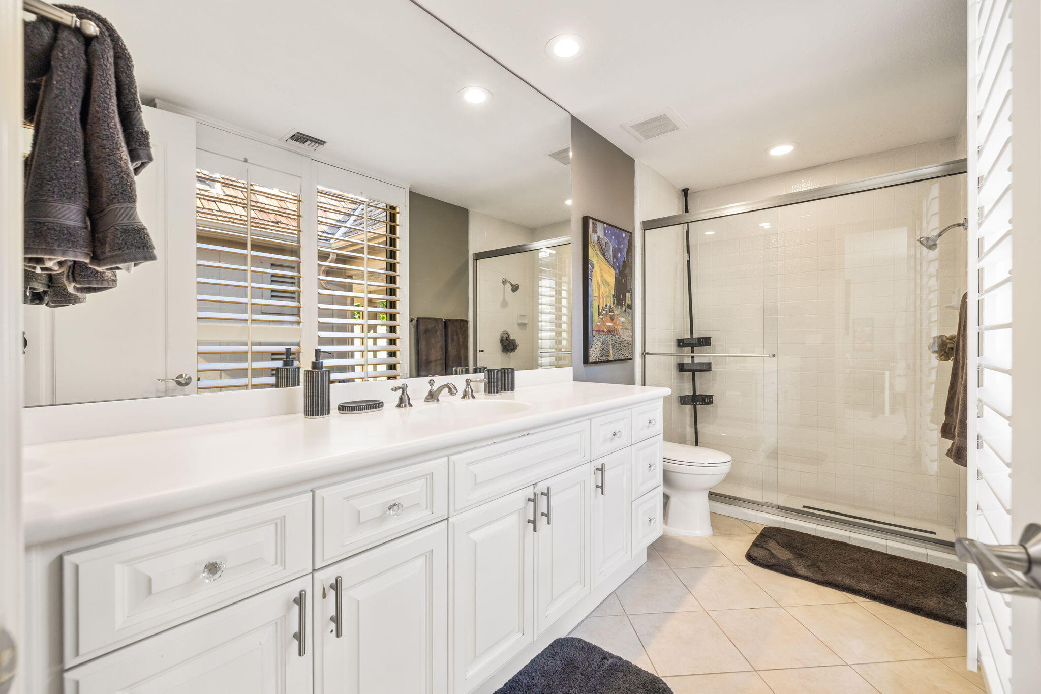 6 Barnard Court Rancho Mirage, CA 92270 - Photo 28 of 58 a bathroom with a double vanity sink a toilet a mirror and shower
