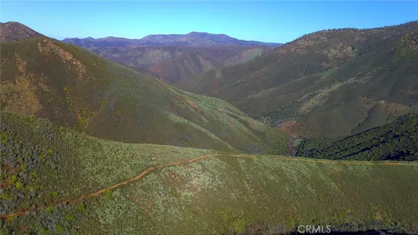 a view of a mountain with a field