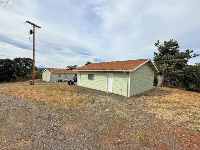 a view of backyard of house and car parked