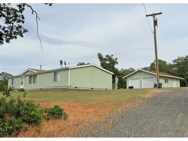 a view of a house with a yard and potted plants