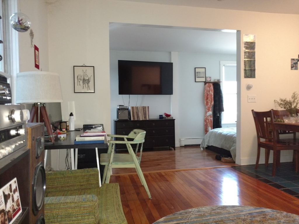 26 Hingham Street, Unit 2 Cambridge, MA 02138 - Photo 4 of 11 a living room with furniture a flat screen tv and kitchen view