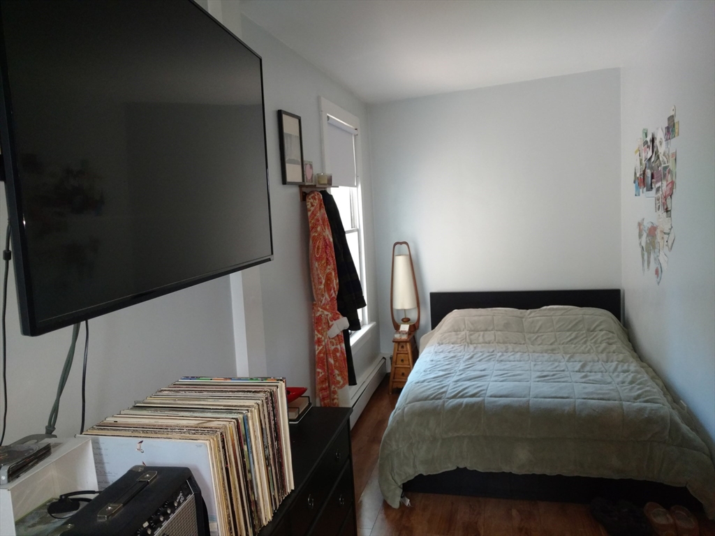 26 Hingham Street, Unit 2 Cambridge, MA 02138 - Photo 6 of 11 a bedroom with a bed next to a window