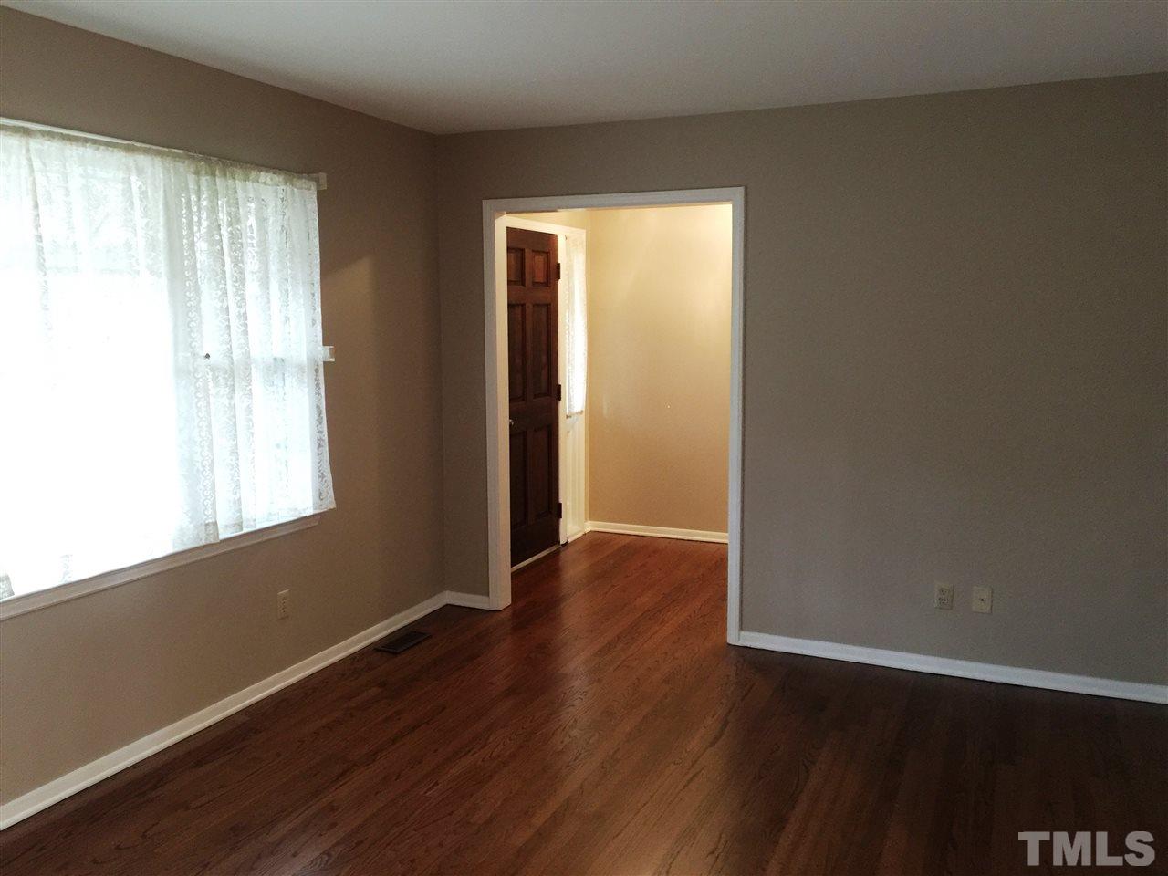 505 East Millbrook Road Raleigh, NC 27609 - Photo 3 of 25 an empty room with wooden floor and windows