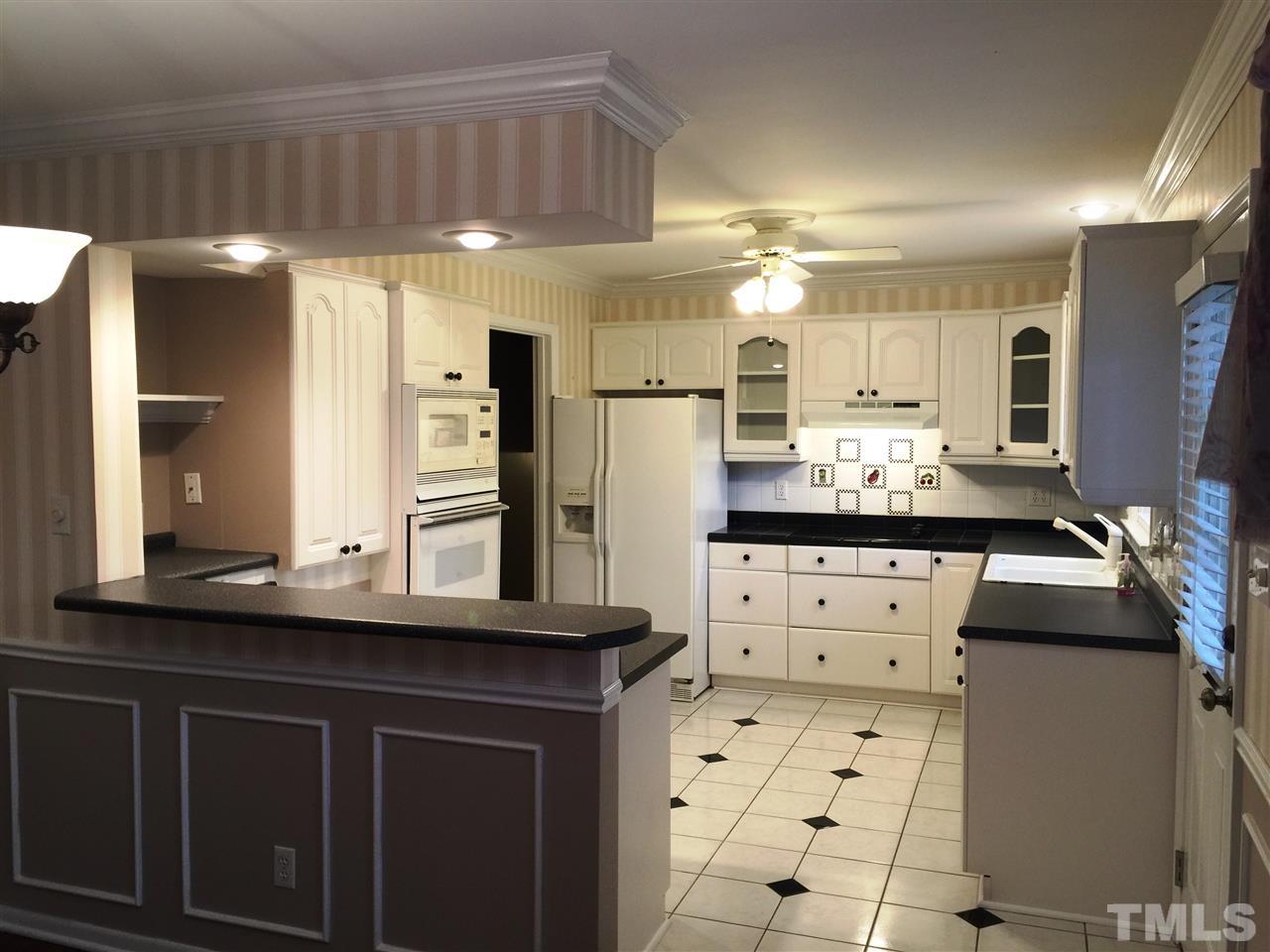 505 East Millbrook Road Raleigh, NC 27609 - Photo 5 of 25 a kitchen with stainless steel appliances kitchen island granite countertop a sink and cabinets