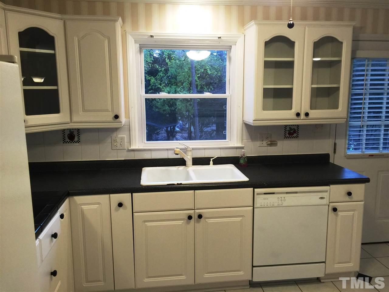 505 East Millbrook Road Raleigh, NC 27609 - Photo 8 of 25 a kitchen with granite countertop white cabinets and black appliances