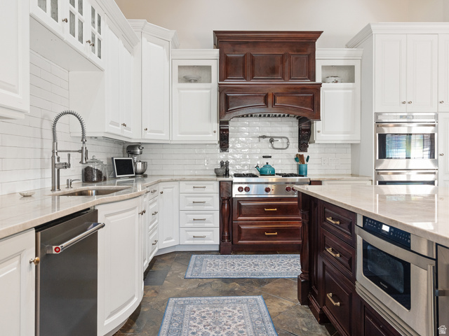 13357 Trail Rider Circle Draper, UT 84020 - Photo 7 of 70 Gourmet kitchen featuring a wood range hood, stainless steel appliances, white cabinetry, a large center island, and stone flooring