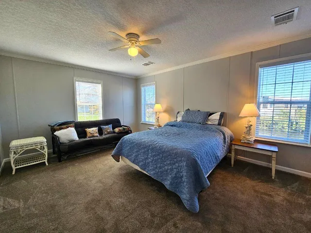 a spacious bedroom with a bed and a chandelier
