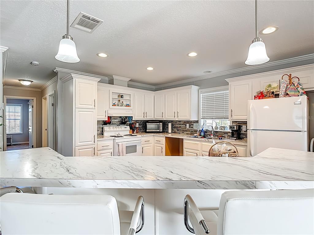 1824 Riverside Drive Moore Haven, FL 33471 - Photo 23 of 66 a kitchen with stainless steel appliances granite countertop a sink and a refrigerator