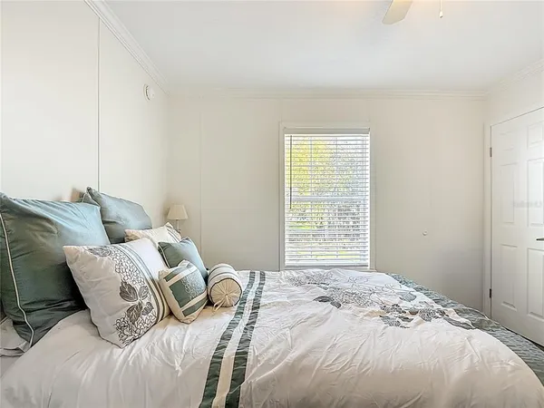 a bedroom with a large bed and a chandelier