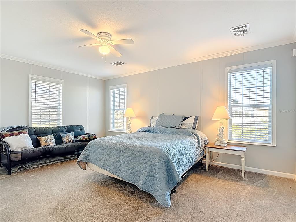 1824 Riverside Drive Moore Haven, FL 33471 - Photo 38 of 66 a bedroom with a bed a couch and a chandelier