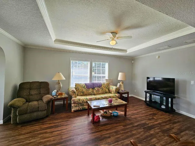 a living room with furniture a flat screen tv and wooden floor