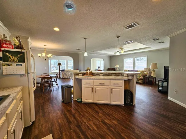 a kitchen with a sink dishwasher a dining table and chairs with wooden floor
