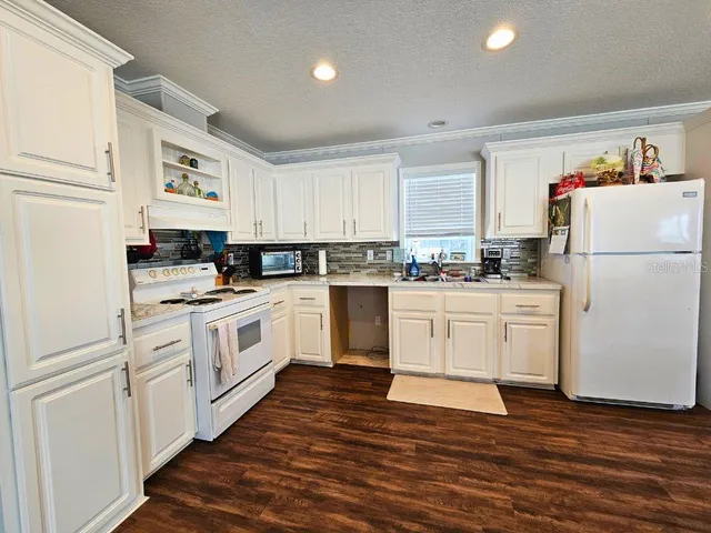 a kitchen with white cabinets and white appliances