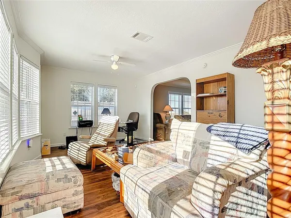 a living room with furniture a chandelier and a dining table