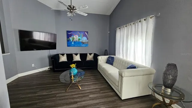 a living room with furniture a flat screen tv and a window