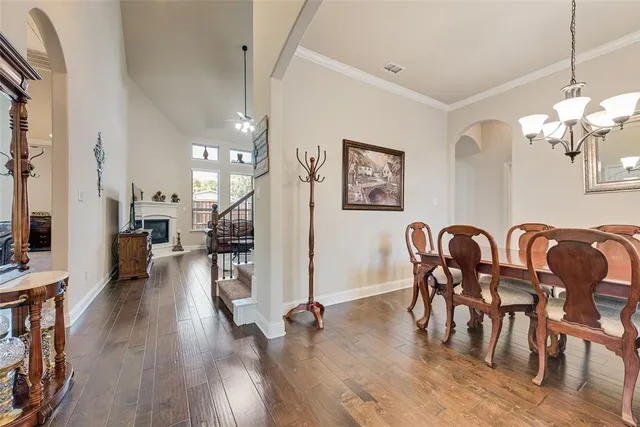 a view of a a dining room with furniture wooden floor and a chandelier