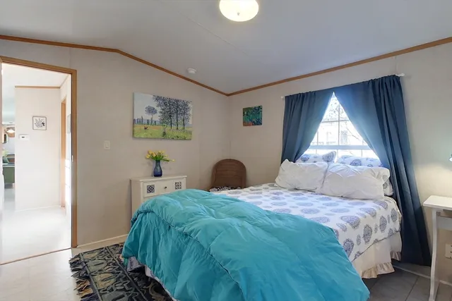 a bedroom with a bed and a large window