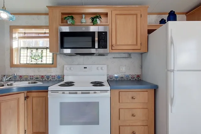 a kitchen with stainless steel appliances a stove microwave and refrigerator