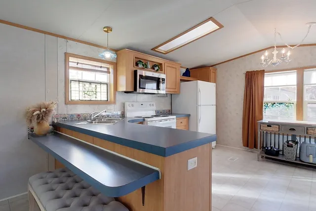 a kitchen with stainless steel appliances granite countertop a sink refrigerator and microwave