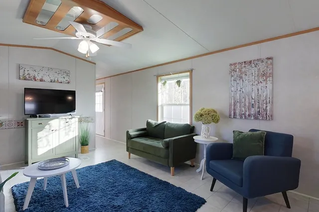a living room with furniture a flat screen tv and a chandelier