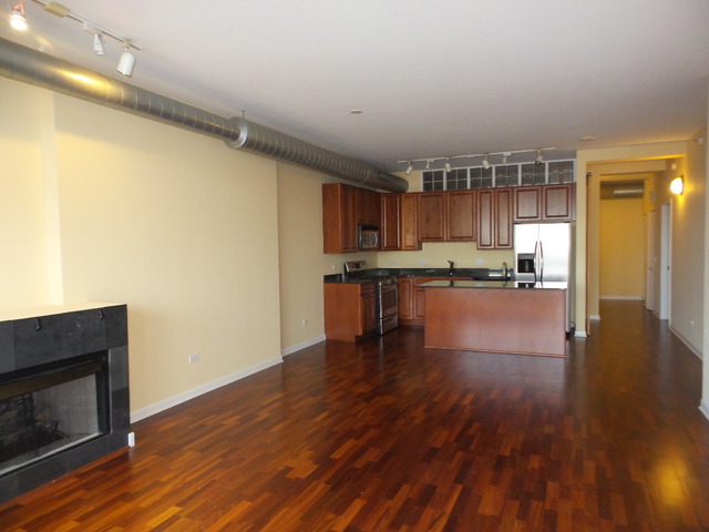 1200 West Monroe Street, Unit 803 Chicago, IL 60607 - Photo 4 of 12 a kitchen with stainless steel appliances wooden floor and a refrigerator