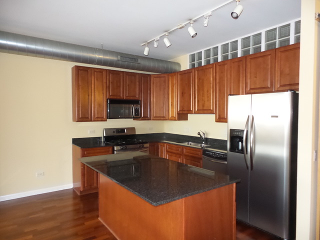 1200 West Monroe Street, Unit 803 Chicago, IL 60607 - Photo 5 of 12 a kitchen with granite countertop a sink stove and refrigerator