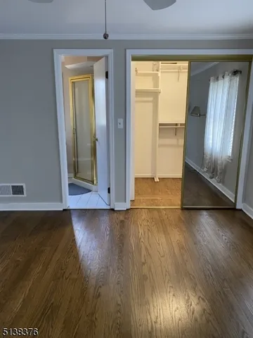 an empty room with wooden floor door and windows
