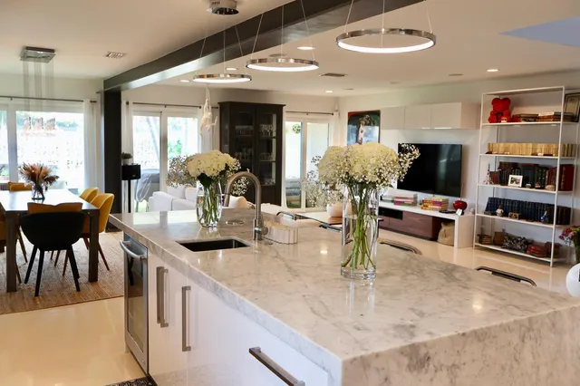 a kitchen with kitchen island granite countertop a table and chairs in it
