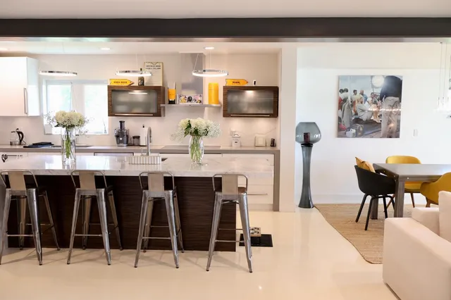 a kitchen with stainless steel appliances kitchen island granite countertop a table and chairs in it
