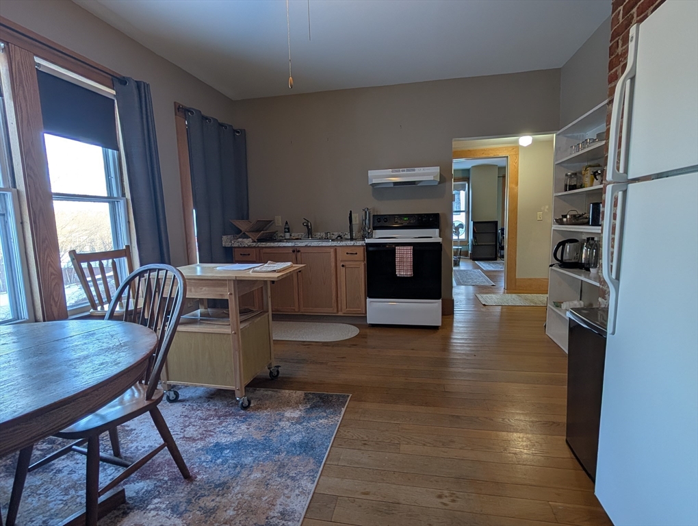 527 Main Street, Unit 2 Ashfield, MA 01330 - Photo 2 of 27 a living room with stainless steel appliances furniture a rug and a kitchen view