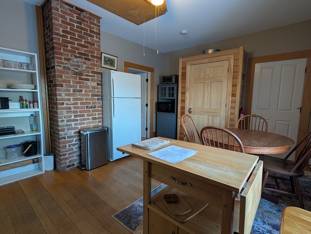 527 Main Street, Unit 2 Ashfield, MA 01330 - Photo 23 of 27 a kitchen with a table chairs and a refrigerator