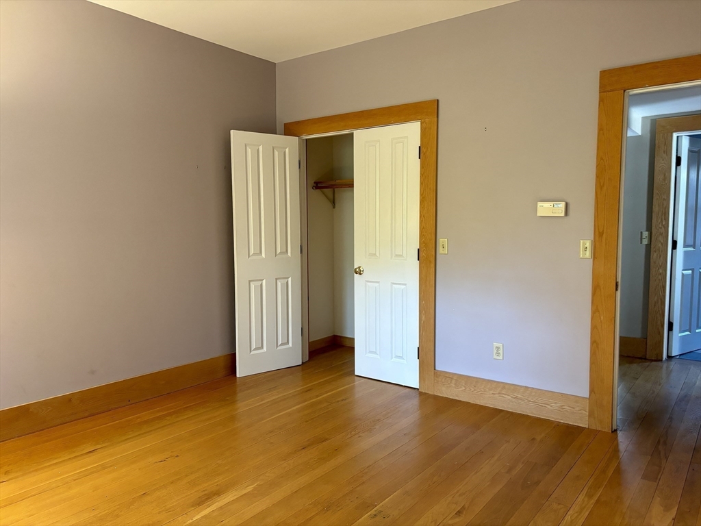 527 Main Street, Unit 2 Ashfield, MA 01330 - Photo 6 of 27 an empty room with wooden floor and closet