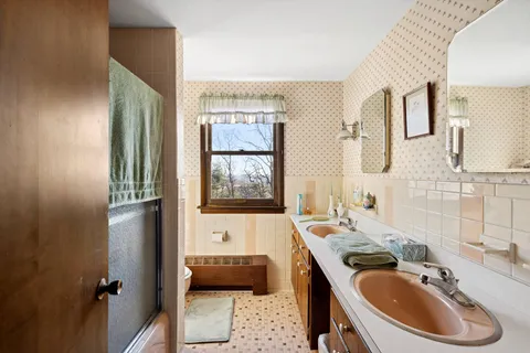 a bathroom with a tub sink and mirror